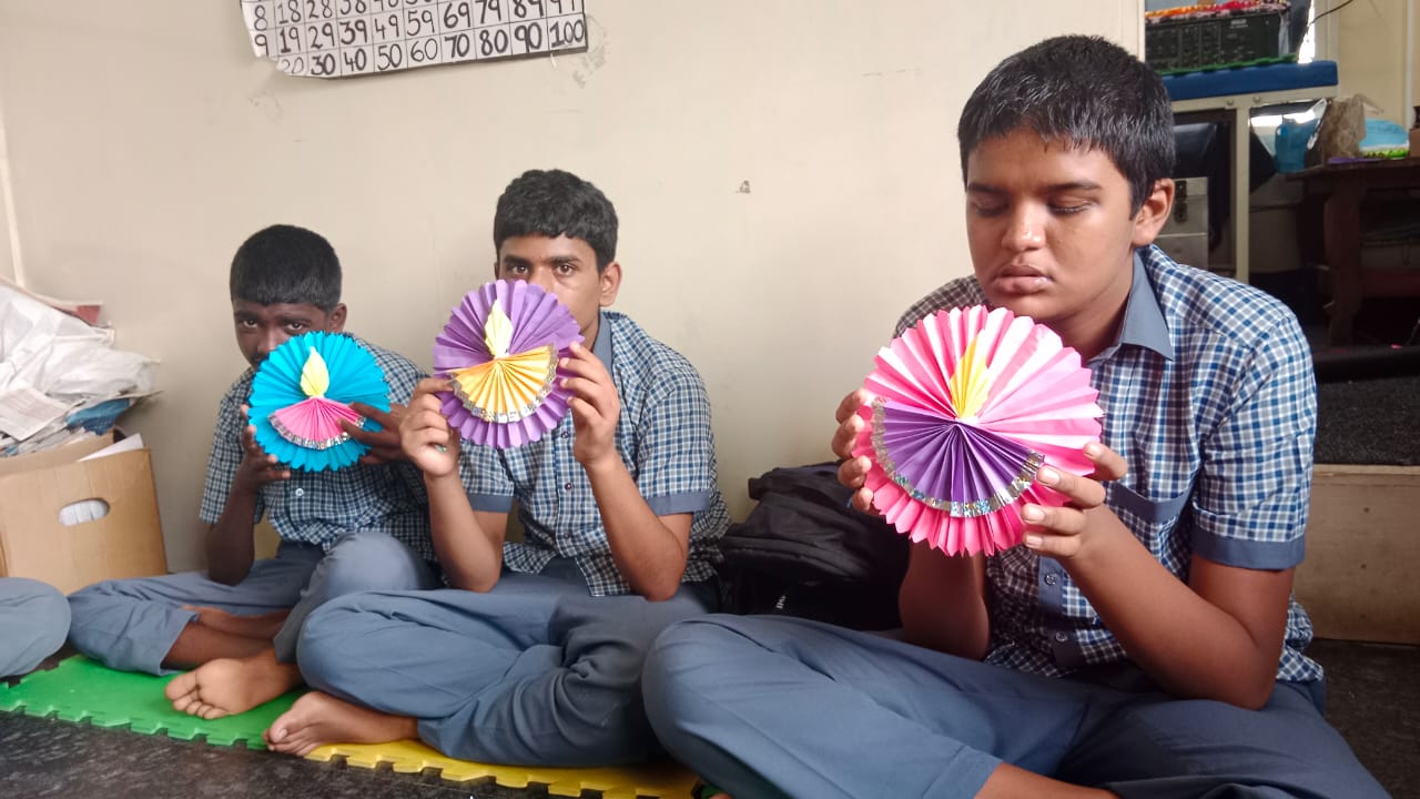 Students displaying colourful handmade paper crafts at Navachethana Trust